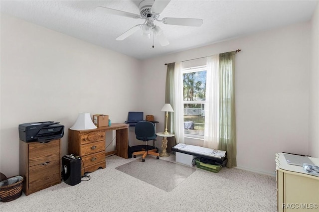 carpeted home office featuring ceiling fan