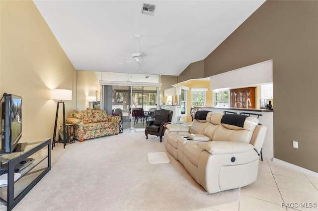 living area featuring light carpet, light tile patterned floors, visible vents, a ceiling fan, and high vaulted ceiling