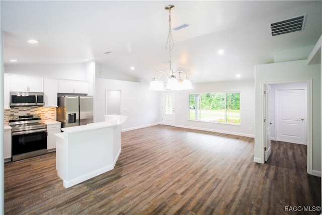 kitchen featuring white cabinetry, dark wood-type flooring, hanging light fixtures, vaulted ceiling, and appliances with stainless steel finishes