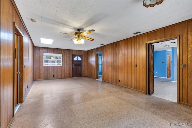 spare room with wooden walls and ceiling fan