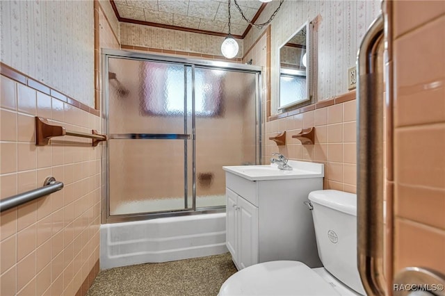 full bathroom featuring tile walls, vanity, shower / bath combination with glass door, and toilet