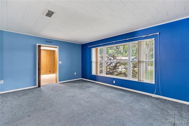 carpeted empty room featuring crown molding