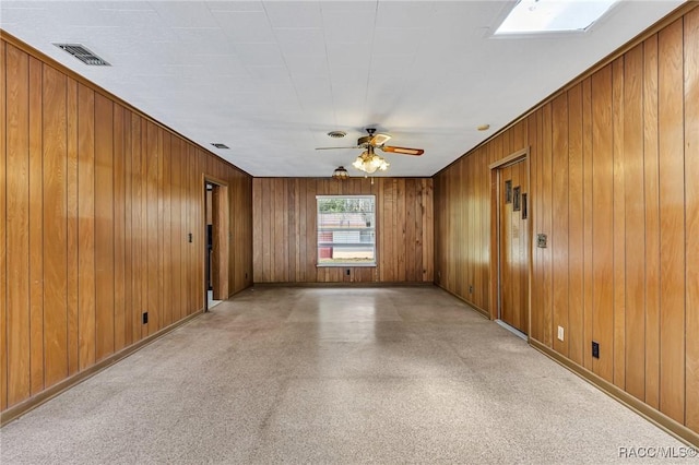 empty room featuring wooden walls and ceiling fan