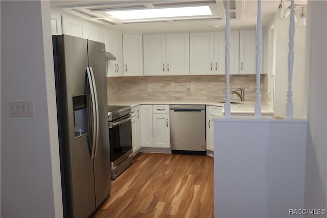 kitchen with white cabinetry, sink, tasteful backsplash, appliances with stainless steel finishes, and light wood-type flooring