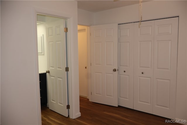 unfurnished bedroom with a chandelier, dark hardwood / wood-style flooring, and a closet