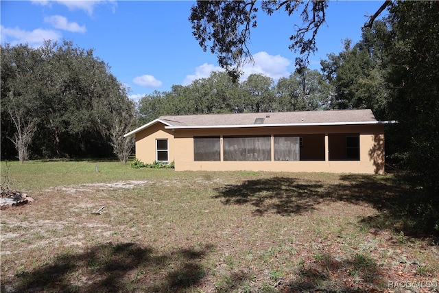 rear view of house featuring a lawn