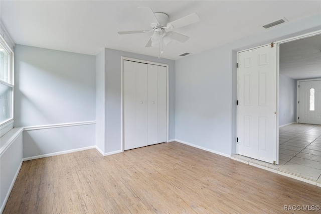 unfurnished bedroom featuring a closet, ceiling fan, and light hardwood / wood-style flooring