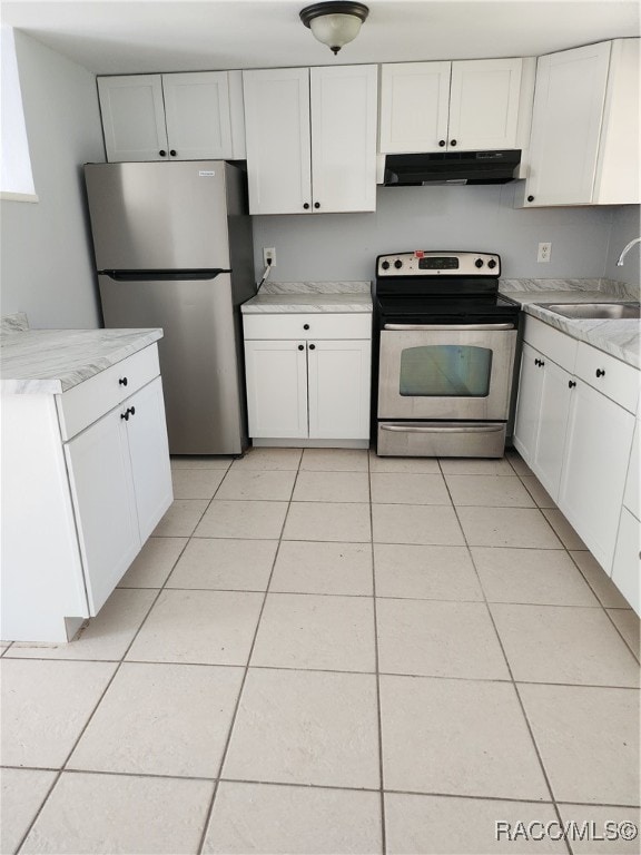 kitchen with white cabinets, light tile patterned floors, stainless steel appliances, and sink