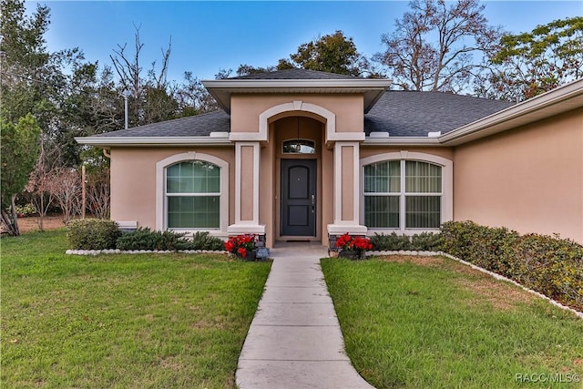 entrance to property with a lawn