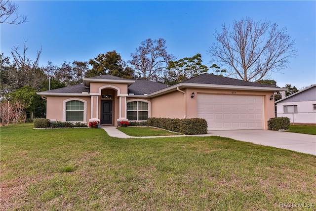 single story home featuring a garage and a front lawn