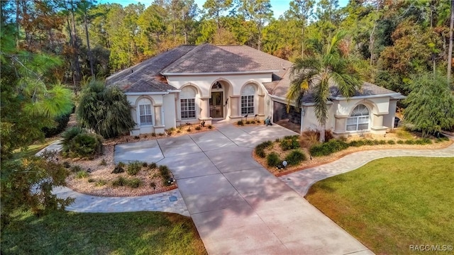 mediterranean / spanish-style house with a garage and a front lawn