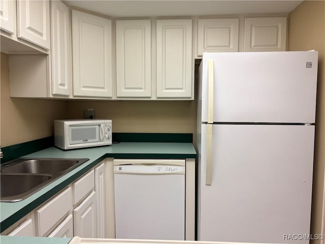 kitchen with white cabinets, sink, and white appliances