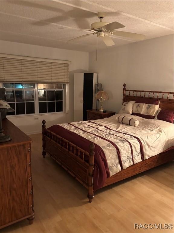 bedroom featuring ceiling fan, a textured ceiling, and hardwood / wood-style flooring