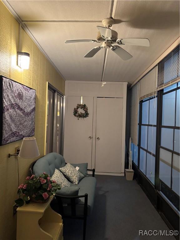 sitting room featuring ceiling fan and carpet floors