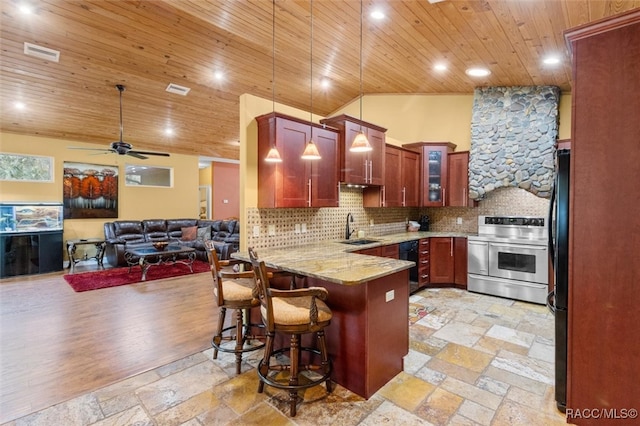 kitchen with sink, kitchen peninsula, decorative light fixtures, lofted ceiling, and appliances with stainless steel finishes