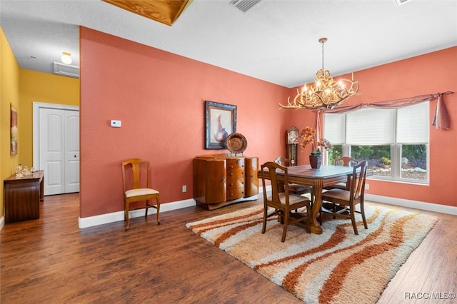 dining room with dark wood-type flooring and a chandelier