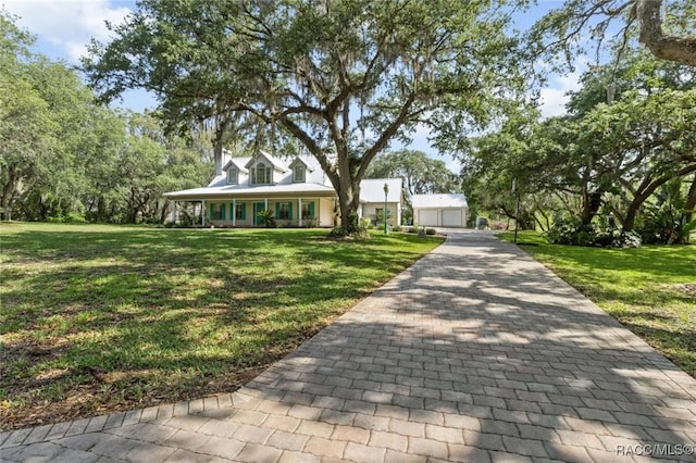 9885 E Lindale Ct, Inverness, FL 34450 - new england style home with a front yard, covered porch, and a detached garage