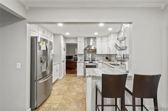 9885 E Lindale Ct, Inverness, FL 34450 - kitchen featuring appliances with stainless steel finishes, wall chimney exhaust hood, a peninsula, light stone finish flooring, and a sink