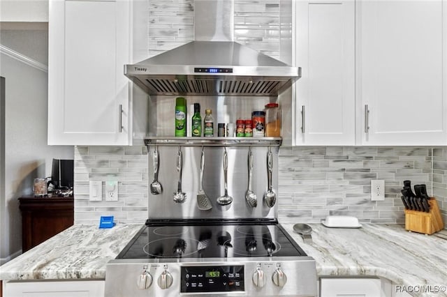 9885 E Lindale Ct, Inverness, FL 34450 - kitchen with wall chimney exhaust hood, tasteful backsplash, white cabinetry, electric stove, and light stone countertops