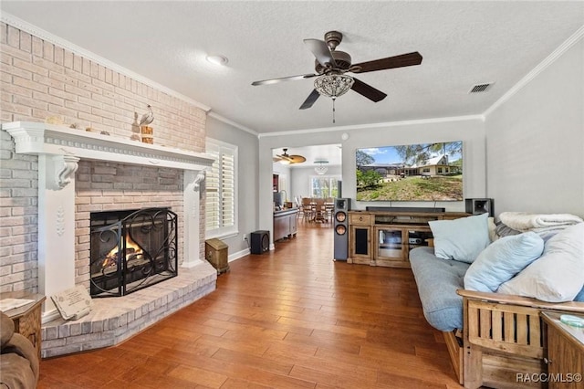 9885 E Lindale Ct, Inverness, FL 34450 - living room with ceiling fan, wood finished floors, ornamental molding, a fireplace, and a textured ceiling