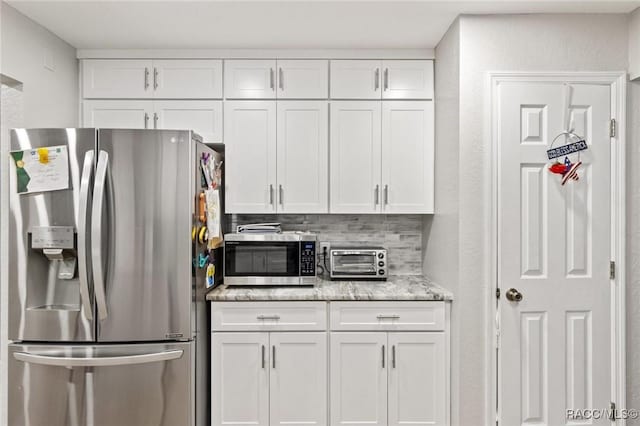 9885 E Lindale Ct, Inverness, FL 34450 - kitchen with stainless steel appliances, white cabinetry, light stone counters, and backsplash