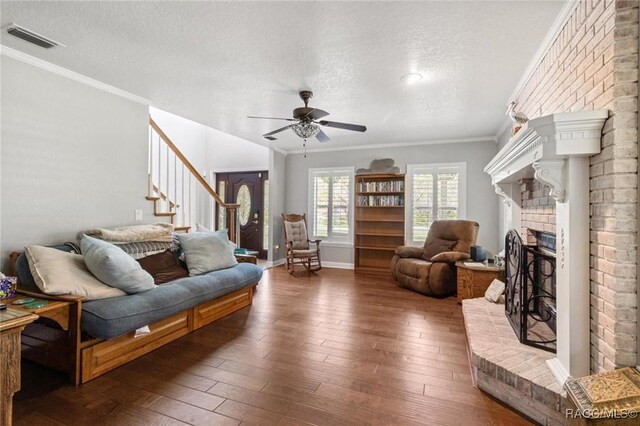 9885 E Lindale Ct, Inverness, FL 34450 - living area with a textured ceiling, stairway, a brick fireplace, hardwood / wood-style floors, and ceiling fan