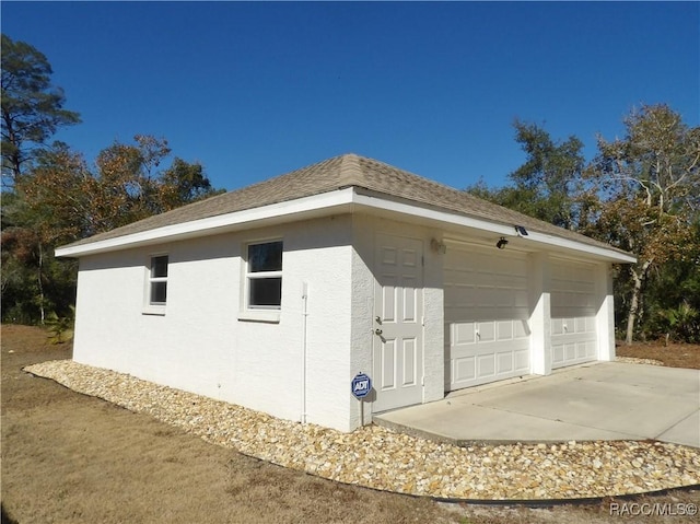 view of side of home featuring a garage and an outdoor structure