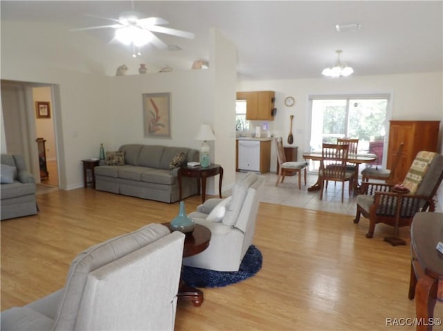 living room with a notable chandelier and light wood-type flooring