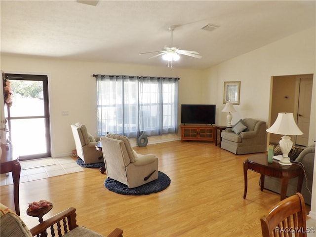 living room with ceiling fan, lofted ceiling, a healthy amount of sunlight, and light wood-type flooring