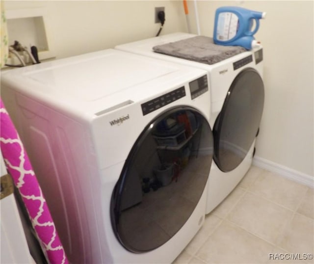 laundry room featuring washing machine and dryer and light tile patterned flooring