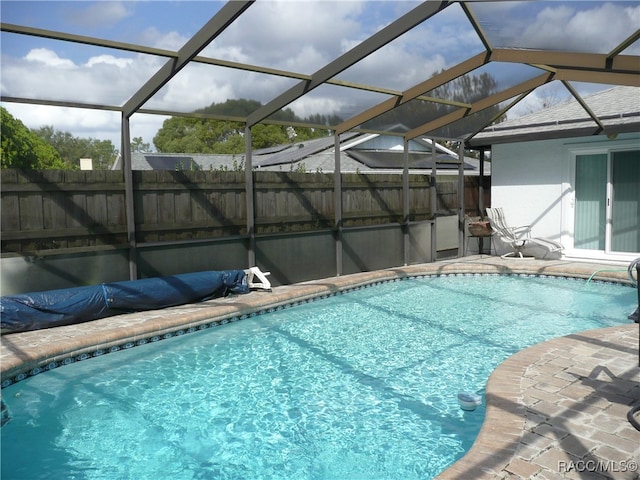 view of pool featuring glass enclosure