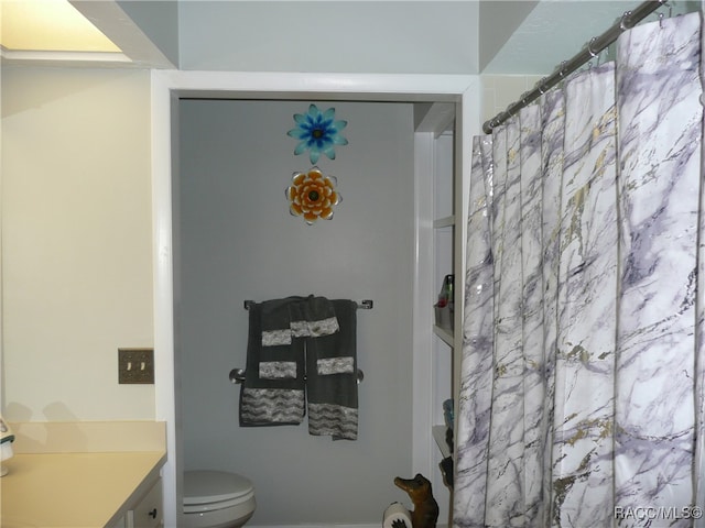 bathroom featuring vanity, toilet, and curtained shower