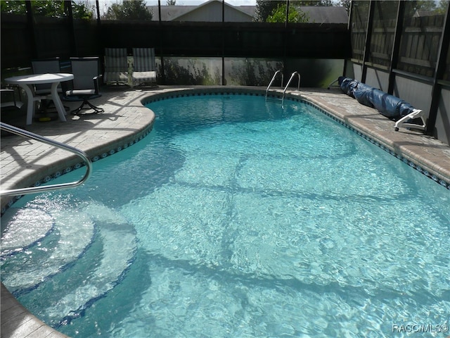 view of swimming pool with a lanai and a patio area