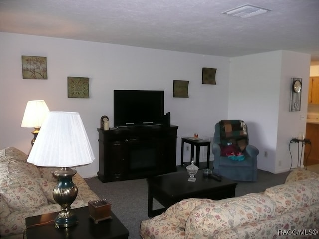 carpeted living room featuring a textured ceiling