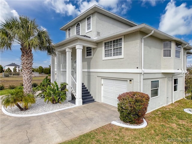 view of front of home featuring concrete driveway, an attached garage, and stucco siding