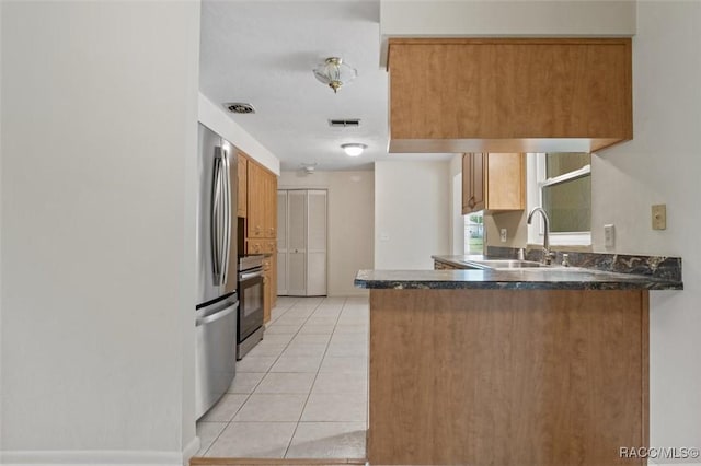 520 S Jefferson St, Beverly Hills, FL 34465 - kitchen with freestanding refrigerator, a peninsula, light tile patterned floors, a sink, and range