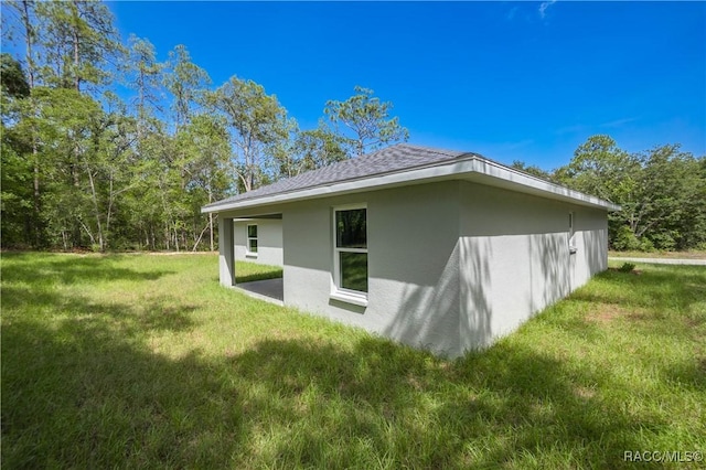 8880 N Circular Way, Citrus Springs, FL 34434 - view of home's exterior with stucco siding, a yard, and roof with shingles