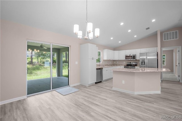 8880 N Circular Way, Citrus Springs, FL 34434 - kitchen with stainless steel appliances, vaulted ceiling, white cabinetry, light wood-style flooring, and light stone countertops