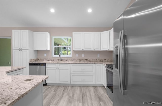 8880 N Circular Way, Citrus Springs, FL 34434 - kitchen featuring appliances with stainless steel finishes, white cabinetry, light stone countertops, light wood-style floors, and recessed lighting
