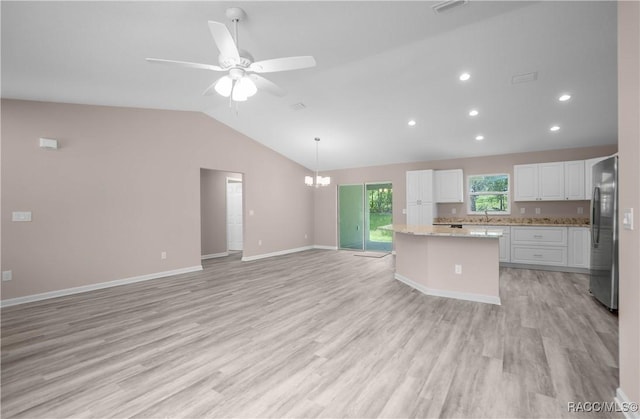 8880 N Circular Way, Citrus Springs, FL 34434 - kitchen featuring freestanding refrigerator, lofted ceiling, a center island, light wood-style floors, and white cabinetry