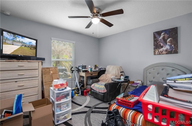 carpeted bedroom featuring ceiling fan and a textured ceiling