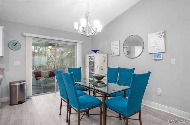 dining space with an inviting chandelier, light hardwood / wood-style flooring, and vaulted ceiling