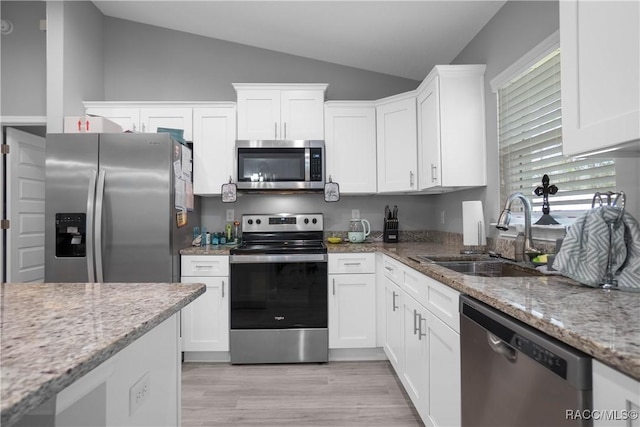 kitchen with sink, stainless steel appliances, white cabinets, and light stone counters