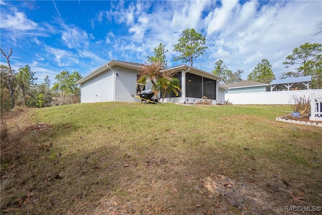 view of front of house featuring a sunroom and a front lawn