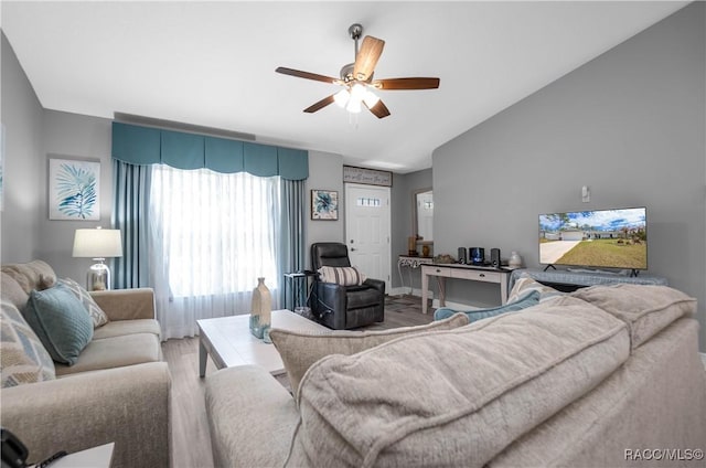 living room featuring hardwood / wood-style flooring, vaulted ceiling, and ceiling fan