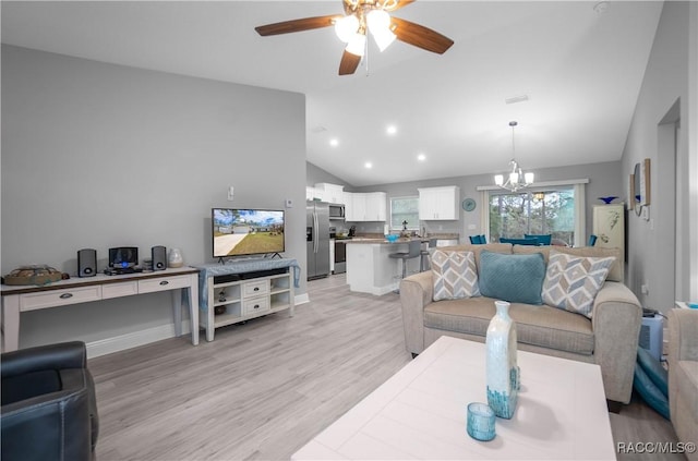 living room with ceiling fan with notable chandelier, light hardwood / wood-style flooring, and vaulted ceiling