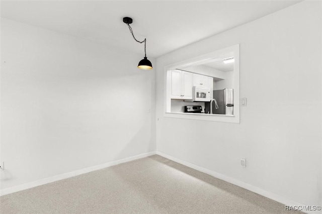 unfurnished dining area featuring carpet flooring and baseboards