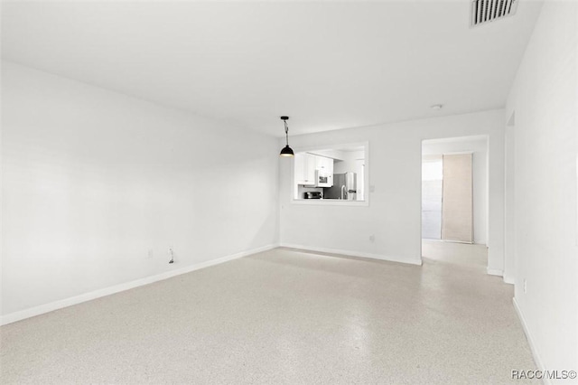 unfurnished living room with light speckled floor, visible vents, and baseboards