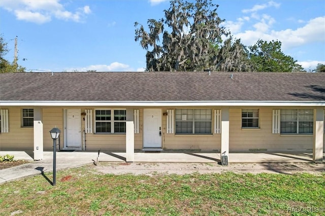 single story home featuring roof with shingles