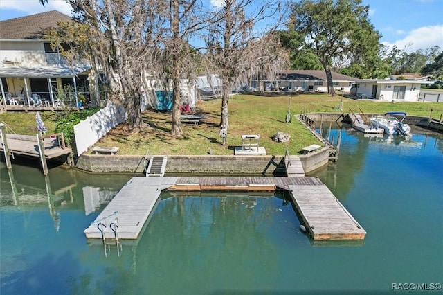 dock area with a yard, a water view, and fence